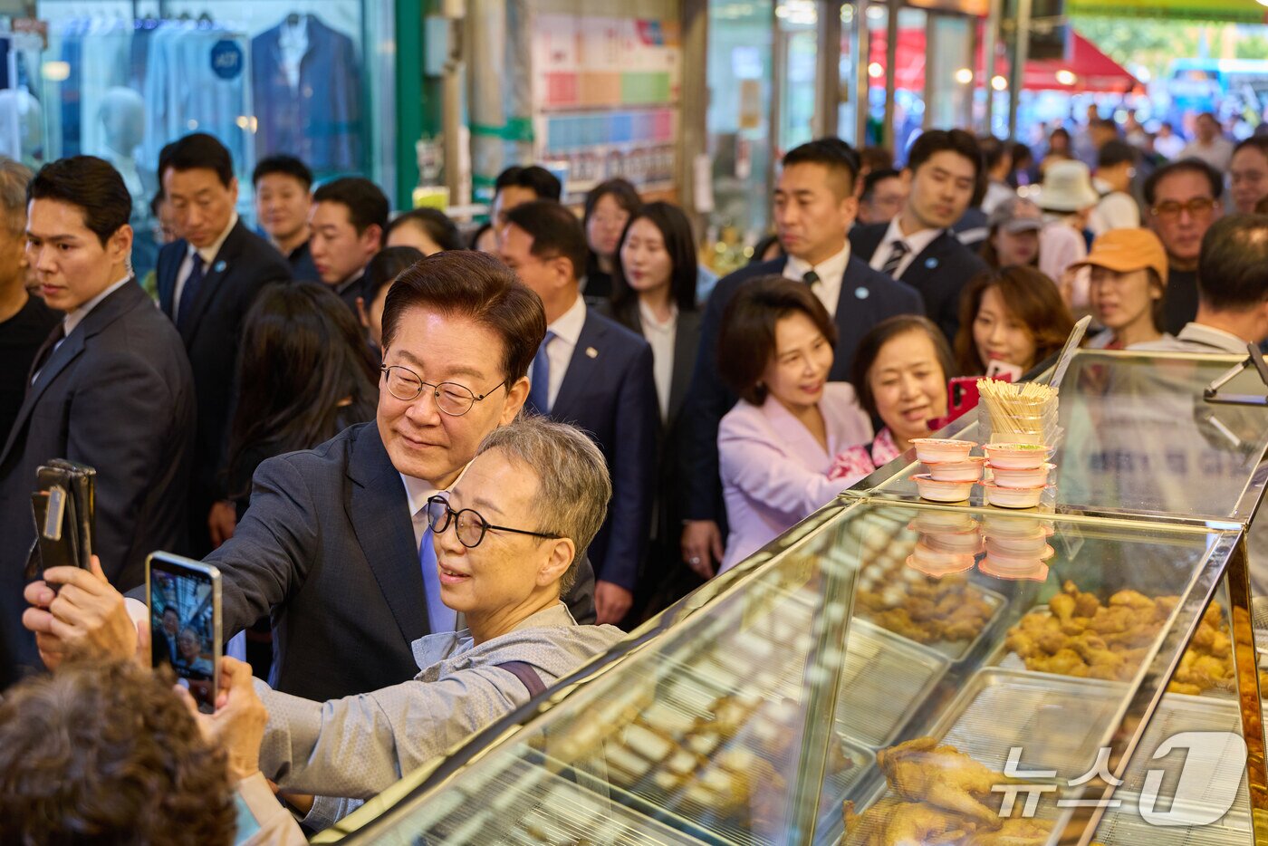 본문 이미지 - 이재명 대통령과 김혜경 여사가 2일 서울 서대문구 영천시장을 찾아 시민들과 기념촬영을 하고 있다. (청와대 제공. 재판매 및 DB 금지) 2026.10.2 ⓒ 뉴스1 이재명 기자
