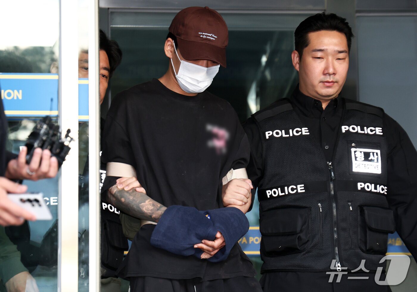 본문 이미지 - 장모를 흉기로 찔러 숨지게 한 뒤 별거하던 부인을 납치해 달아난 혐의로 구속된 26살 남성 김성우가 20일 오전 서울 송파구 송파경찰서에서 공소청으로 송치되고 있다. 2026.10.20 ⓒ 뉴스1 최지환 기자