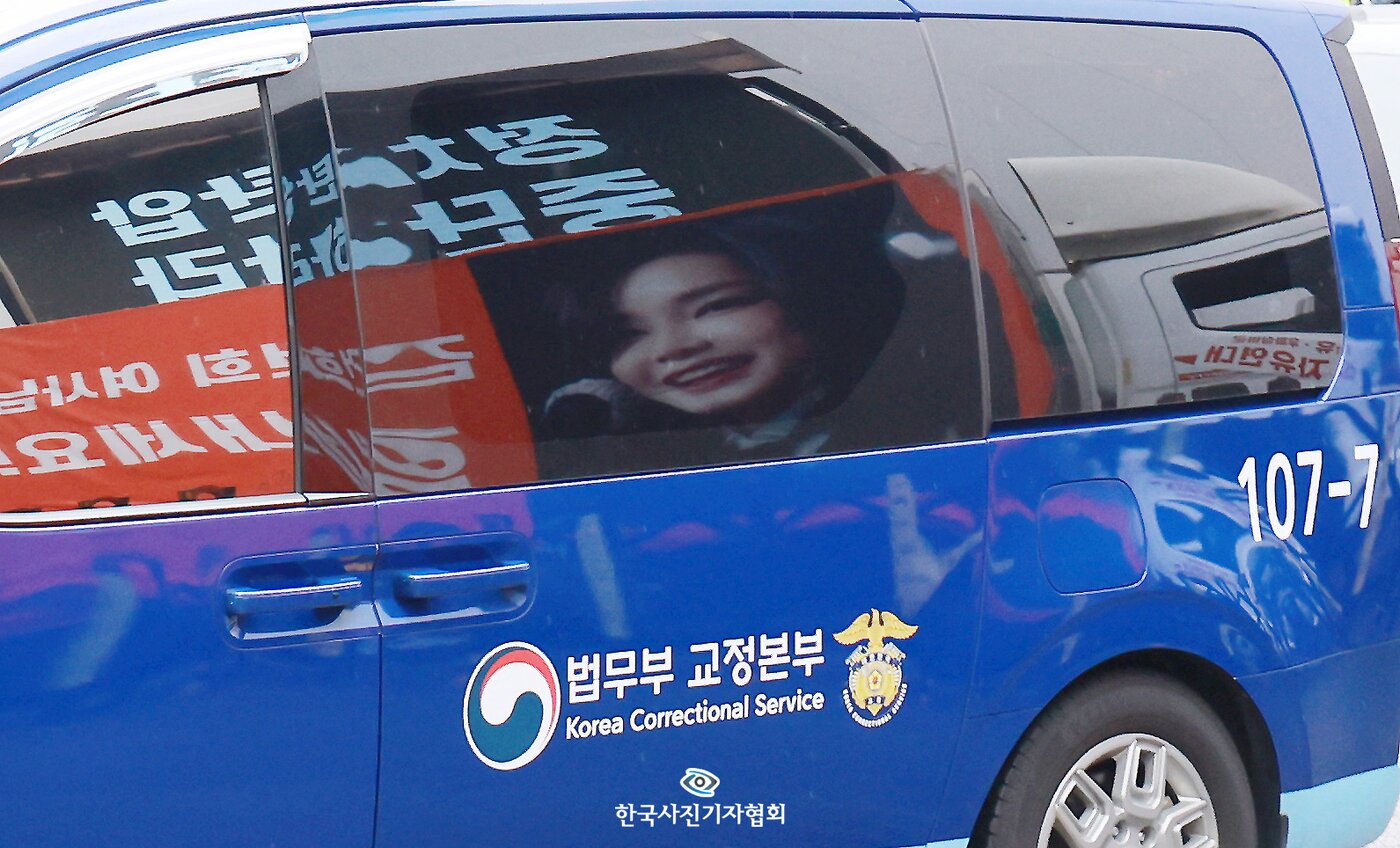본문 이미지 - 호송차량에 비친 김건희 여사의 얼굴 2026.10.21 ⓒ 뉴스1  이호윤 기자
