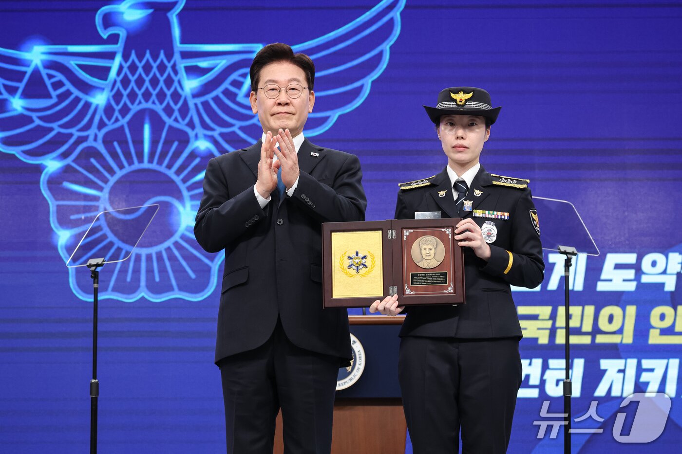 본문 이미지 - 이재명 대통령이 21일 서울 서대문구 경찰청에서 열린 제81주년 경찰의 날 기념식에서 경감 김선현의 딸 김성은 경장에게 올해의 경찰영웅 인증패를 전달한 후 기념촬영 하고 있다. (청와대통신사진기자단) 2026.10.21 ⓒ 뉴스1 이재명 기자