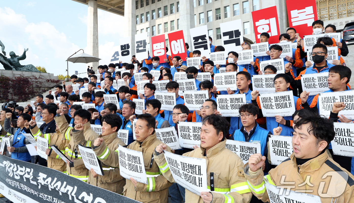 (서울=뉴스1) 김명섭 기자 = 21일 서울 영등포구 여의도 국회의사당 계단에서 대한민국공무원노동조합총연맹 소방공무원노동조합원들이 소방공무원 명예회복과 소방조직 정상화 촉구 기자회 …