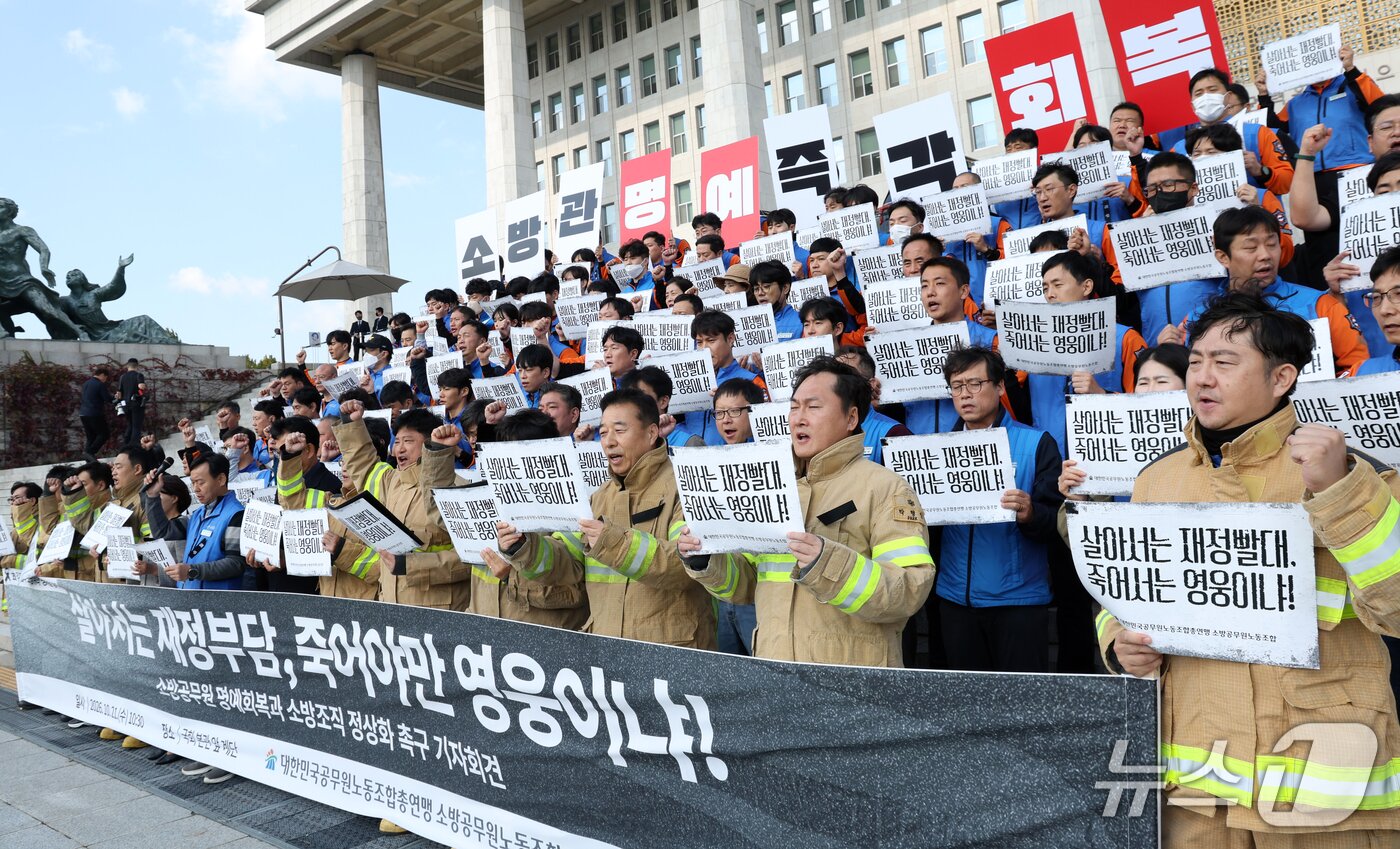 본문 이미지 - 21일 서울 영등포구 여의도 국회의사당 계단에서 대한민국공무원노동조합총연맹 소방공무원노동조합원들이 소방공무원 명예회복과 소방조직 정상화 촉구 기자회견을 하고 있다. 2026.10.21 ⓒ 뉴스1 김명섭 기자