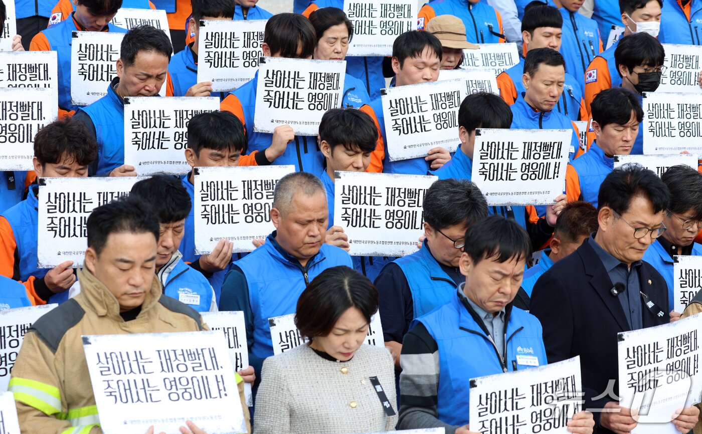본문 이미지 - 21일 서울 영등포구 여의도 국회의사당 계단에서 열린 대한민국공무원노동조합총연맹 소방공무원노동조합원들이 소방공무원 명예회복과 소방조직 정상화 촉구 기자회견에서 희생된 소방관들에 대한 묵념을 하고 있다. 2026.10.21 ⓒ 뉴스1 김명섭 기자