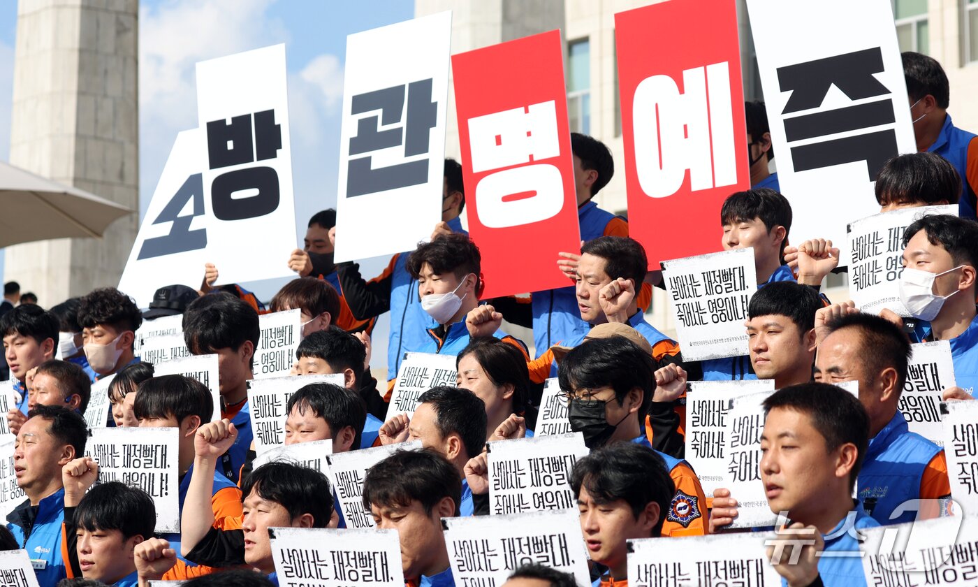본문 이미지 - 21일 서울 영등포구 여의도 국회의사당 계단에서 대한민국공무원노동조합총연맹 소방공무원노동조합원들이 소방공무원 명예회복과 소방조직 정상화 촉구 기자회견을 하고 있다. 2026.10.21 ⓒ 뉴스1 김명섭 기자