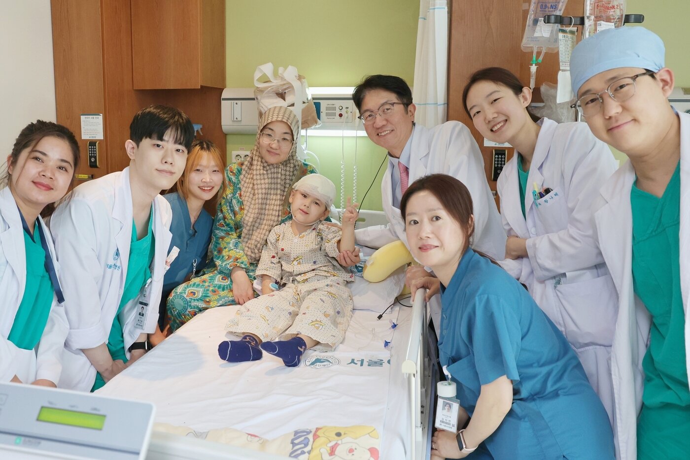 본문 이미지 - 우마르의 엄마, 우마르, 최종우 서울아산병원 성형외과 교수를 비롯한 서울아산병원 의료진이 지난 14일 우마르의 퇴원을 기념하며 사진 촬영을 하고 있다.(병원 제공)