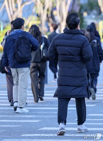 본문 이미지 - 서울 아침 5도로 기온이 큰 폭으로 떨어진 22일 오전 서울 종로구 광화문 네거리에서 롱패딩을 입은 시민이 발걸음을 옮기고 있다. 2026.10.22 ⓒ 뉴스1 안은나 기자