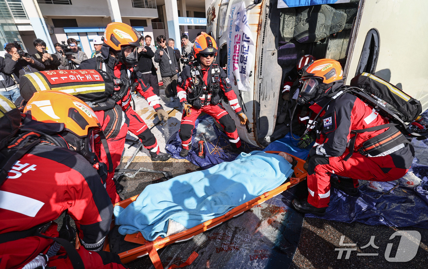 (서울=뉴스1) 이종수 기자 = 22일 서울 양천구 목동종합운동장에서 열린 ‘2026 재난대응 안전한국훈련’에서 119 구조대원들이 화재 차량에서 부상자를 구조하고 있다. 2026 …