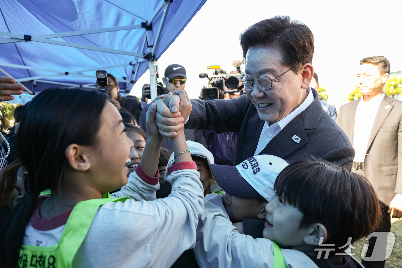 (익산=뉴스1) 이재명 기자 = 이재명 대통령이 22일 전북 익산 왕궁초등학교에서 열린 가을 행복학교 체육한마당에서 어린이들과 인사를 나누고 있다. (청와대통신사진기자단) 2026 …