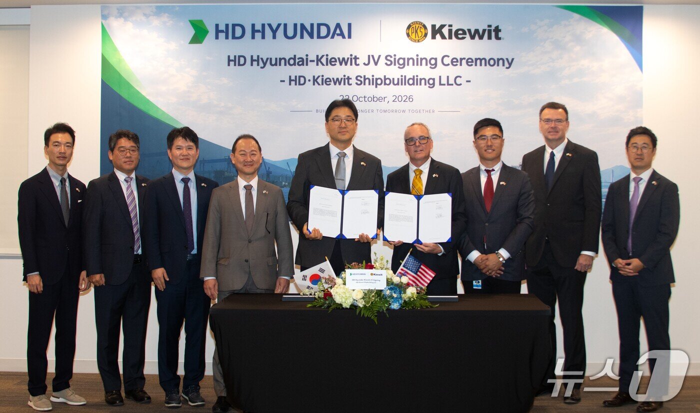 본문 이미지 - HD현대가 22일(현지시간) 미국 키윗(Kiewit) 사와 조선 합작법인 설립을 위한 계약을 체결한 모습. 왼쪽에서 다섯 번째부터 최한내 HD한국조선해양 기획부문장, 채드 존슨 키윗 마리타임 CEO.(HD현대 제공) 2026.10.23