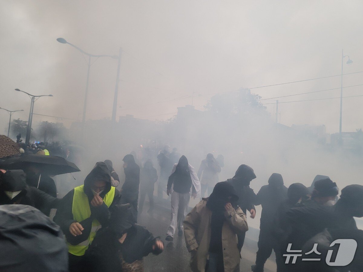 본문 이미지 - (파리=뉴스1 이지예 객원기자) 파리 포르트 드 뱅센 시위에서 경찰의 최루가스를 피하는 참가자들. 2026.10.24