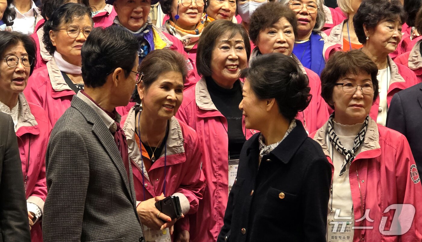 본문 이미지 - 박근혜 전 대통령이 지난 25일 구미 호텔금오산에서 열린 파독간호사 구미 방문 환영만찬에서 기념사진 촬영 중 파독 간호사와 대화를 나누고 있다. 2026.10.25 ⓒ 뉴스1 정우용 기자