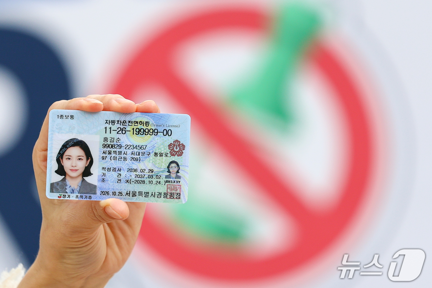 (서울=뉴스1) 안은나 기자 = 한국도로교통공단 관계자가 26일 서울 강서운전면허시험장에서 열린 2026 음주운전 근절 캠페인에서 음주운전 방지장치 부착 조건부 운전면허증을 들어 …