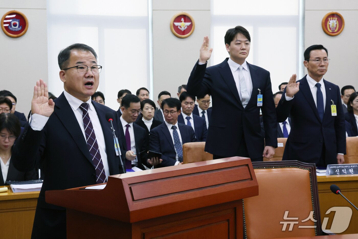 본문 이미지 - 신상균 글로벌국방연구포럼 위원(왼쪽부터) 이주은 퍼플하트 사무국장, 신익현 LIG디펜스&에어로스페이스 대표이사가 26일 서울 여의도 국회 국방위원회에서 열린 국방부 등에 대한 국정감사 종합감사에서 증인으로 출석, 선서를 하고 있다. 2026.10.26 ⓒ 뉴스1 황기선 기자