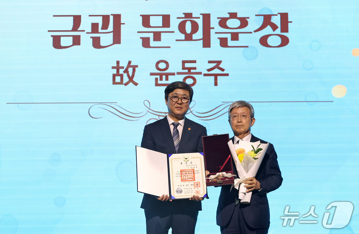 (서울=뉴스1) 김성진 기자 = 최휘영 문화체육관광부 장관이 26일 서대문구 모두예술극장에서 열린 '2026 문화예술 유공 시상식'에서 故 윤동주 시인 유가족에게 금관 문화훈장을 …