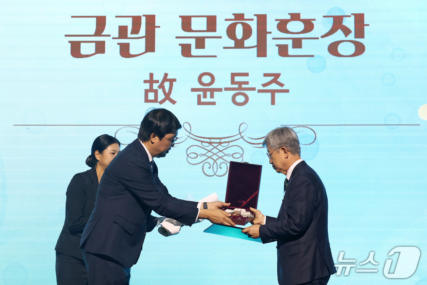 (서울=뉴스1) 김성진 기자 = 최휘영 문화체육관광부 장관이 26일 서대문구 모두예술극장에서 열린 '2026 문화예술 유공 시상식'에서 故 윤동주 시인 유가족에게 금관 문화훈장을 …