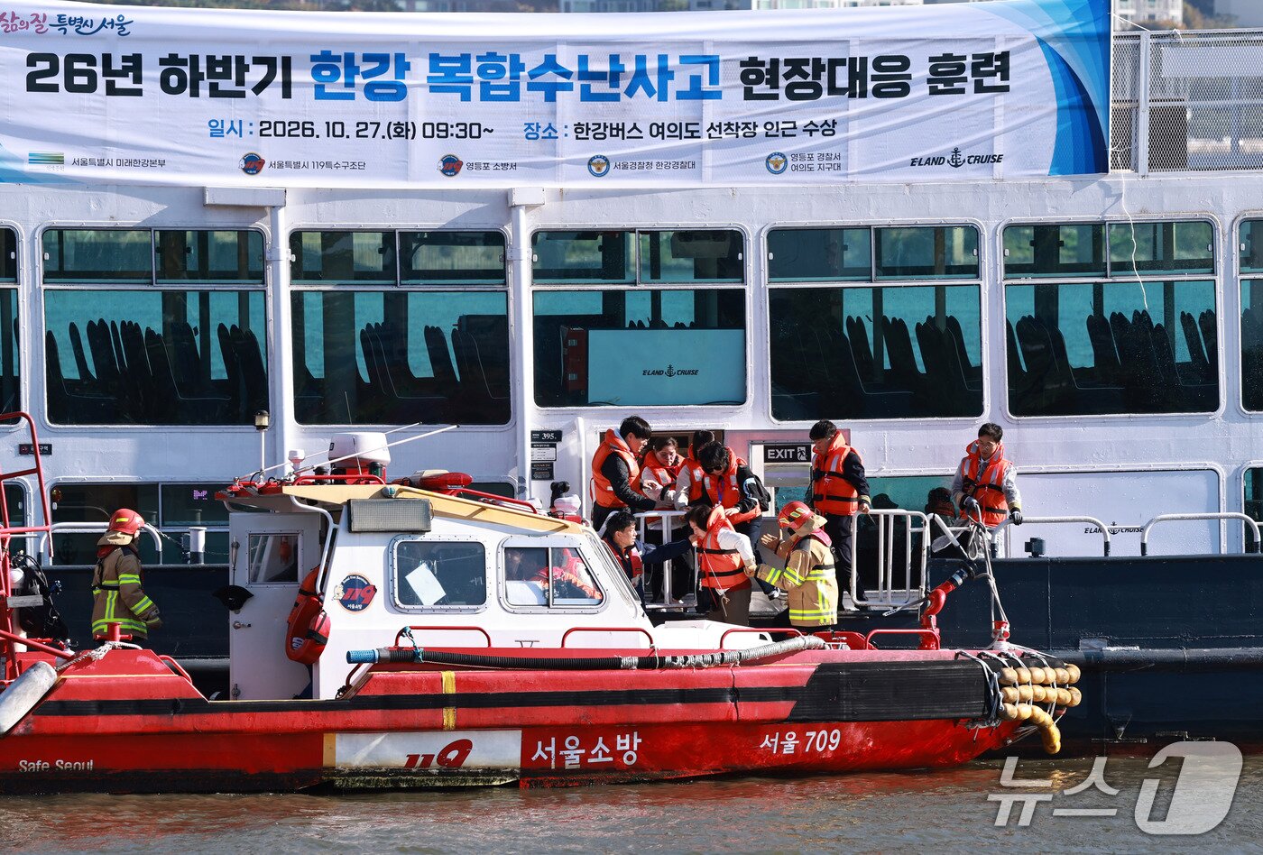 본문 이미지 - 27일 서울 영등포구 한강버스 여의도 선착장 인근에서 유람선 방화 상황을 가정해 열린 '한강 복합 수난사고 현장대응 종합훈련'에서 구조대원들이 탑승객들을 구조하고 있다. 2026.10.27 ⓒ 뉴스1 구윤성 기자