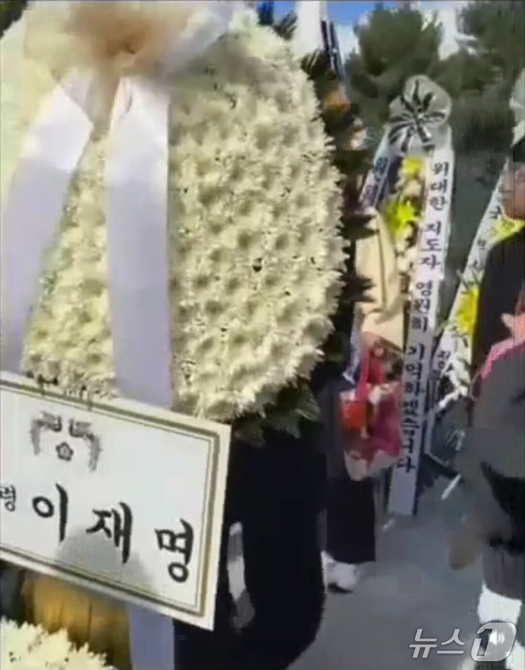 본문 이미지 - 26일 박정희 전 대통령의 추모식에서 한 시민이 이재명 대통령 명의로 설치된 화환을 옮기고 있다.(쓰레드 캡쳐. 재판매 및 DB 금지)2026.10.27/뉴스1