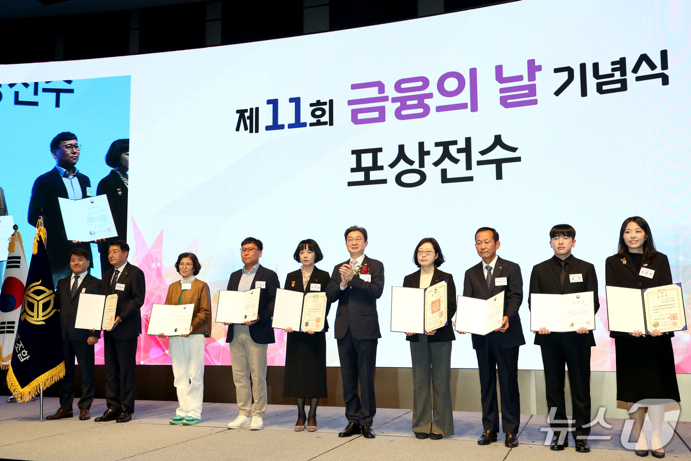 (서울=뉴스1) 이광호 기자 = 이억원 금융위원장이 27일 오전 서울 중구 웨스틴조선호텔에서 열린 제11회 금융의 날 기념식에서 포상전수를 마친뒤 수상자들과 기념 촬영을 하고 있다 …