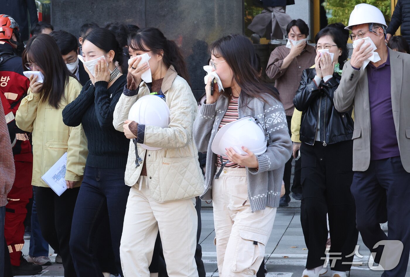 본문 이미지 - 27일 서울 종로구 정부서울청사 화재 대피 민방위 훈련에서 공무원들이 입을 가린 채 청사 건물 밖으로 대피하고 있다. 2026.10.27 ⓒ 뉴스1 이종덕 기자