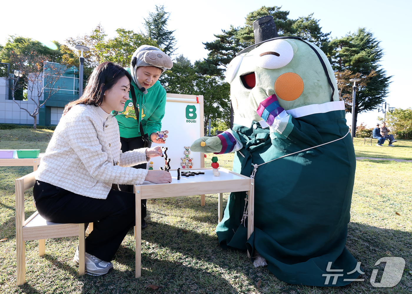 (대구=뉴스1) 공정식 기자 = 27일 대구 수성구 수성못 상화동산에서 열린 '2026 수성국제비엔날레'를 찾은 시민이 수성구 대표 캐릭터 '뚜비'와 함께 탑 쌓기 놀이를 즐기고 …
