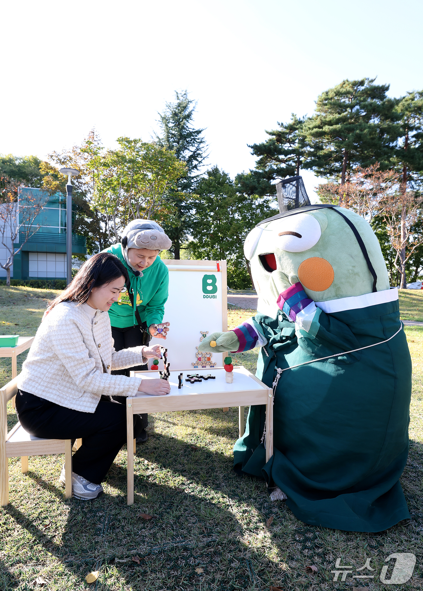 (대구=뉴스1) 공정식 기자 = 27일 대구 수성구 수성못 상화동산에서 열린 '2026 수성국제비엔날레'를 찾은 시민이 수성구 대표 캐릭터 '뚜비'와 함께 탑 쌓기 놀이를 즐기고 …