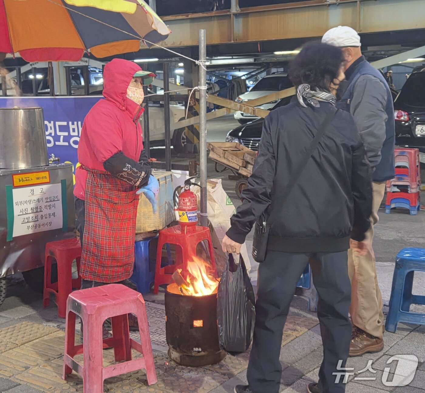 본문 이미지 - 부산 지역 체감온도가 4도까지 뚝 떨어진 28일 새벽, 부산공동어시장 상인들이 미니 화로 주위에 모여 언 몸을 녹이고 있다. 2026.10.28/뉴스1 ⓒ News1 임순택 기자