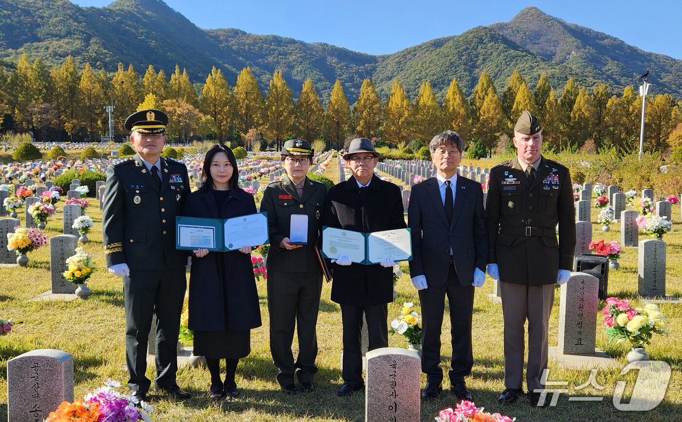 본문 이미지 - 28일 대전 유성구 국립대전현충원에서 열린 고(故) 남운수 상병 추모식에서 정일연 국민권익위원장과 유가족, 이철수 육군 제9사단 행정부사단장, 미 8군사령부 관계자가 이날 헌정 받은 은성무공훈장을 들어 보이고 있다. (국민권익위원회 제공. 재판매 및 DB 금지) 2026.10.28 ⓒ 뉴스1