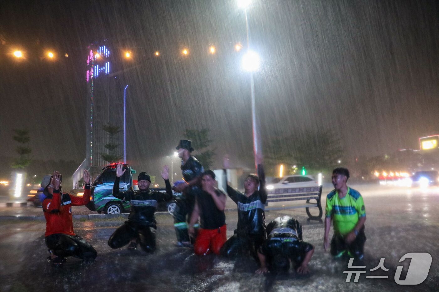 (팔랑카야 AFP=뉴스1) 김범수 기자 = 28일(현지시간) 인도네시아 중부 칼리만탄주 팔랑카야에서 수개월간 산불이 이어진 가운데 의용소방대원들이 쏟아지는 비를 맞으며 환호하고 있 …