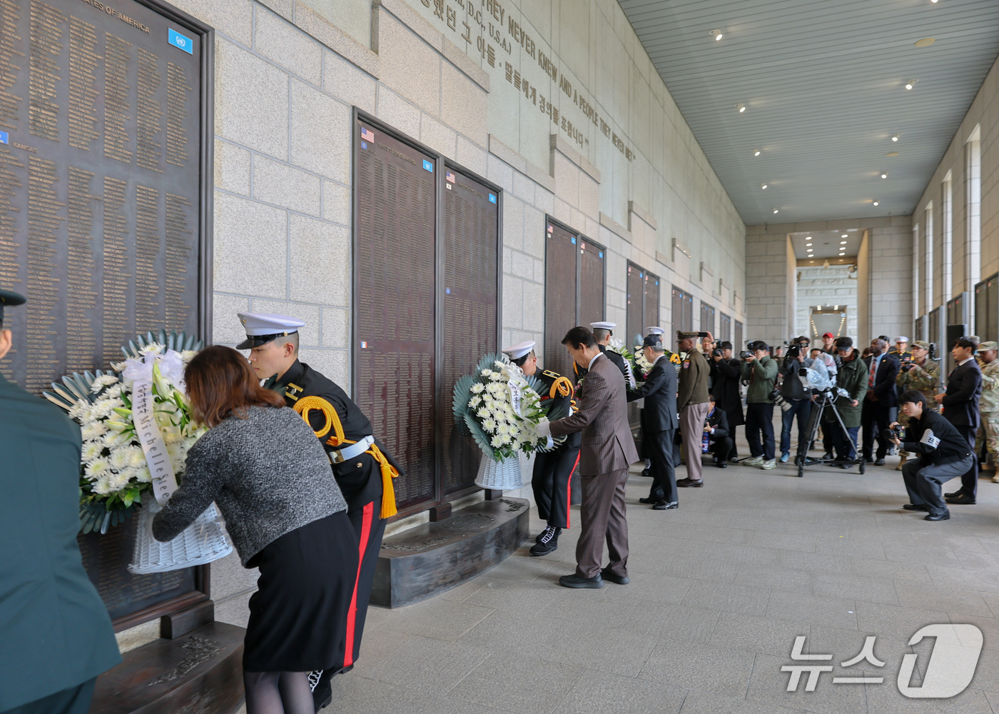 (서울=뉴스1) = 권오을 국가보훈부 장관이 29일 오후 서울 용산구 전쟁기념관에서 제76주년 장진호 전투 기념 및 추모행사 참석자들과 함께 전사자 명비에 헌화하고 있다. (국가보 …