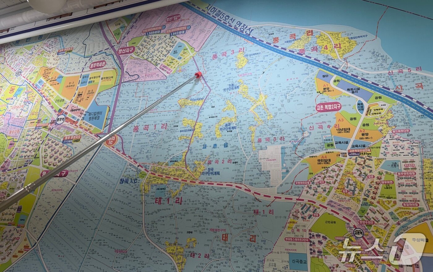 본문 이미지 - 29일 경기 김포시 고촌읍의 한 공인중개사가 국토교통부가 발표한 신규 택지 위치를 가리키고 있다. 국토부는 고촌읍 일대 365만㎡ 부지에 3만 7000가구 주택 공급 계획을 내놨다. 2026.10.29 ⓒ 뉴스1 김종훈 기자
