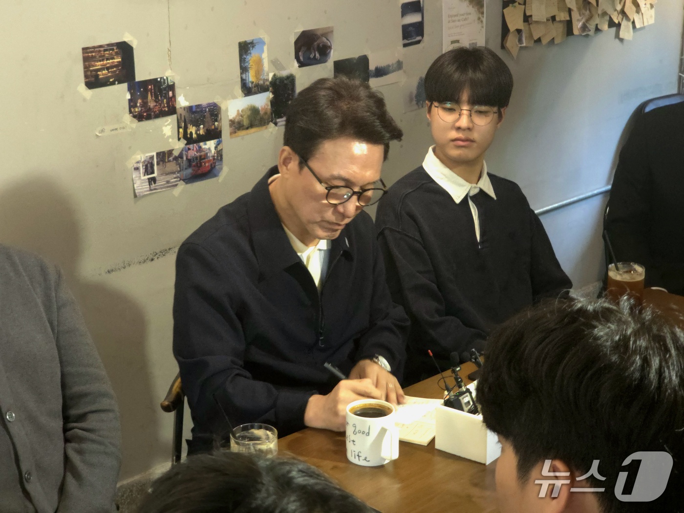 (부산=뉴스1) 이주현 기자 = 김민석 더불어민주당 대표가 3일 부산 부산진구의 한 카페에서 가진 청년 간담회에서 참석자의 발언을 메모하고 있다.2026.10.3/뉴스1