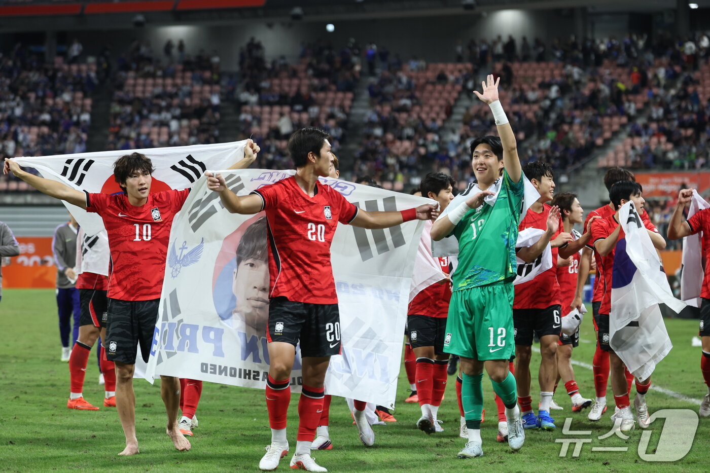 본문 이미지 - 3일 일본 아이치현 도요타 스타디움에서 열린 2026 아이치·나고야 아시안게임 남자 축구 결승전 대한민국과 일본의 경기, 1대 0으로 승리하며 금메달을 획득한 대한민국 선수들이 태극기를 두르고 기쁨을 나누고 있다. 2026.10.3 ⓒ 뉴스1 김도우 기자