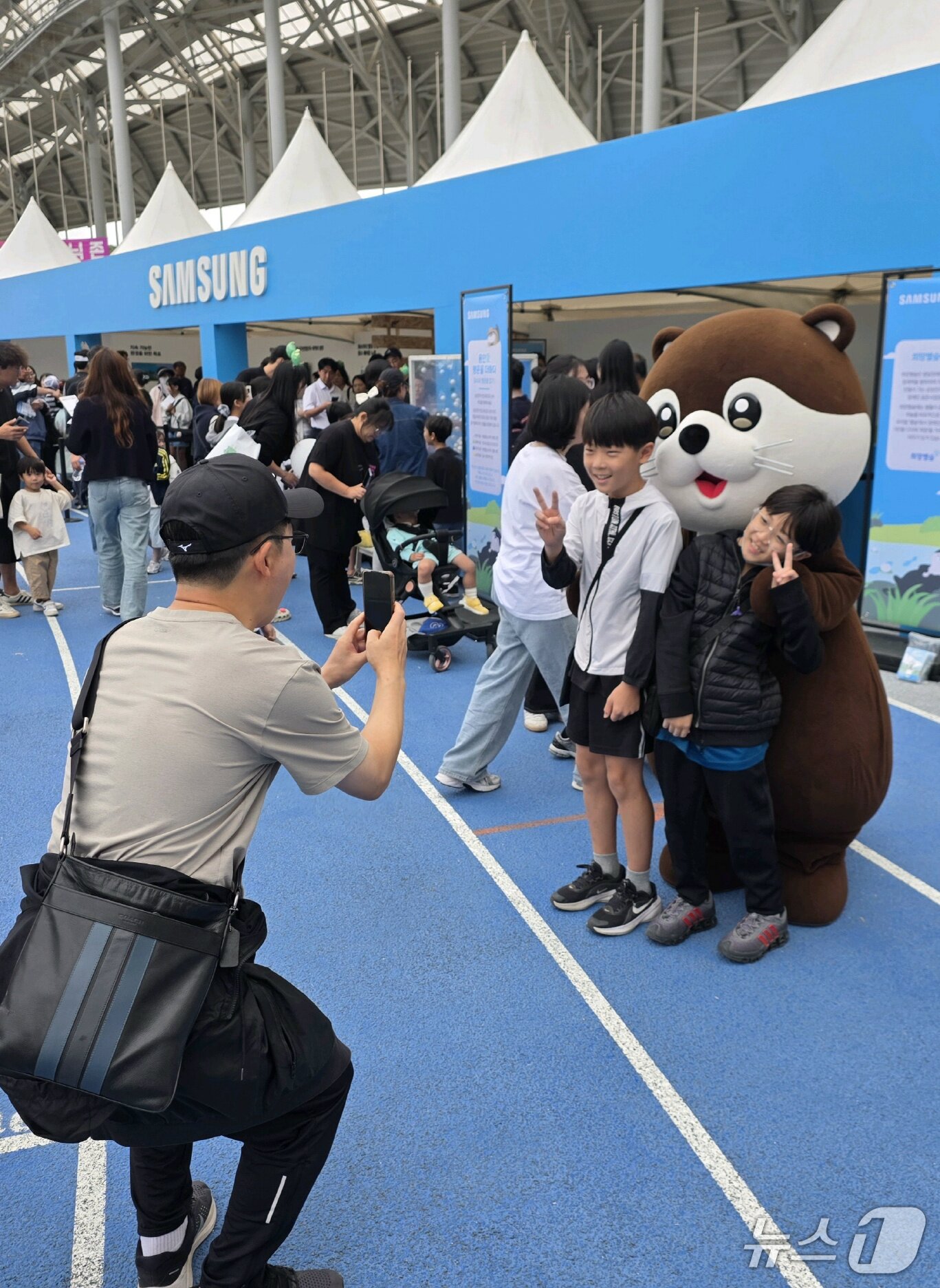 본문 이미지 - 3일 '2026 용인 사이버 과학축제'에 참여한 청소년들이 삼성전자 DS부문 친환경 캐릭터인 '달수'와 기념 촬영을 하고 있다. (삼성전자 제공) 