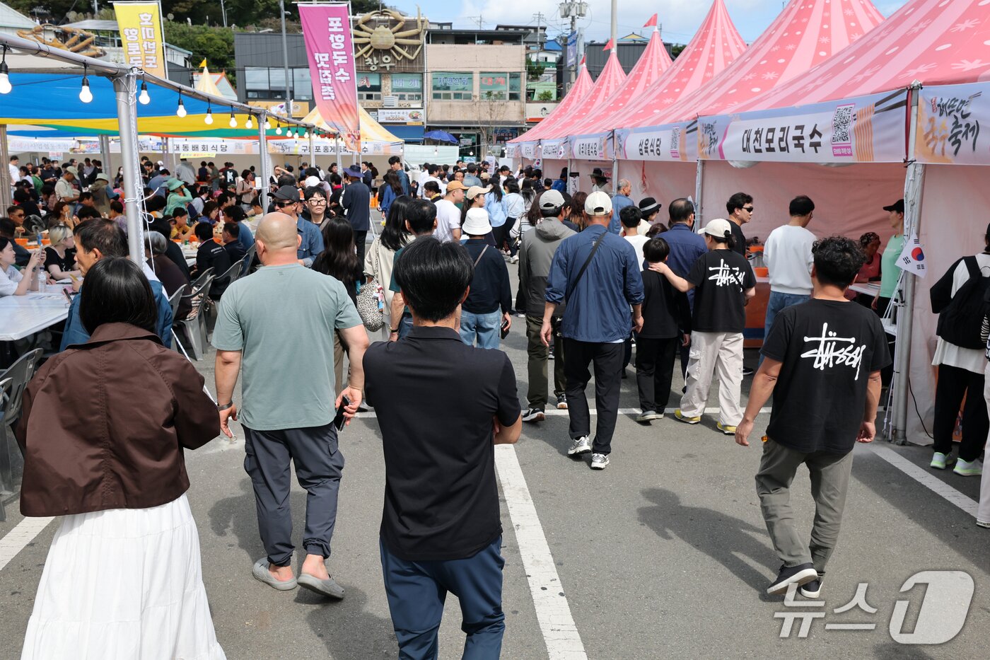 본문 이미지 - 4일 오후 경북 포항시 남구 구룡포 아라광장에서 열린 '해뜨면 국수축제'에 관광객들이 몰려 크게 붐볐다. 축제에는 포항지역 국수 맛집 24곳과 일본·중국 현지 셰프들이 사누키우동, 양저우 양춘면 시식 코너를 마련해 무료로 나눠줬다. 2026.10.4 ⓒ 뉴스1 최창호 기자