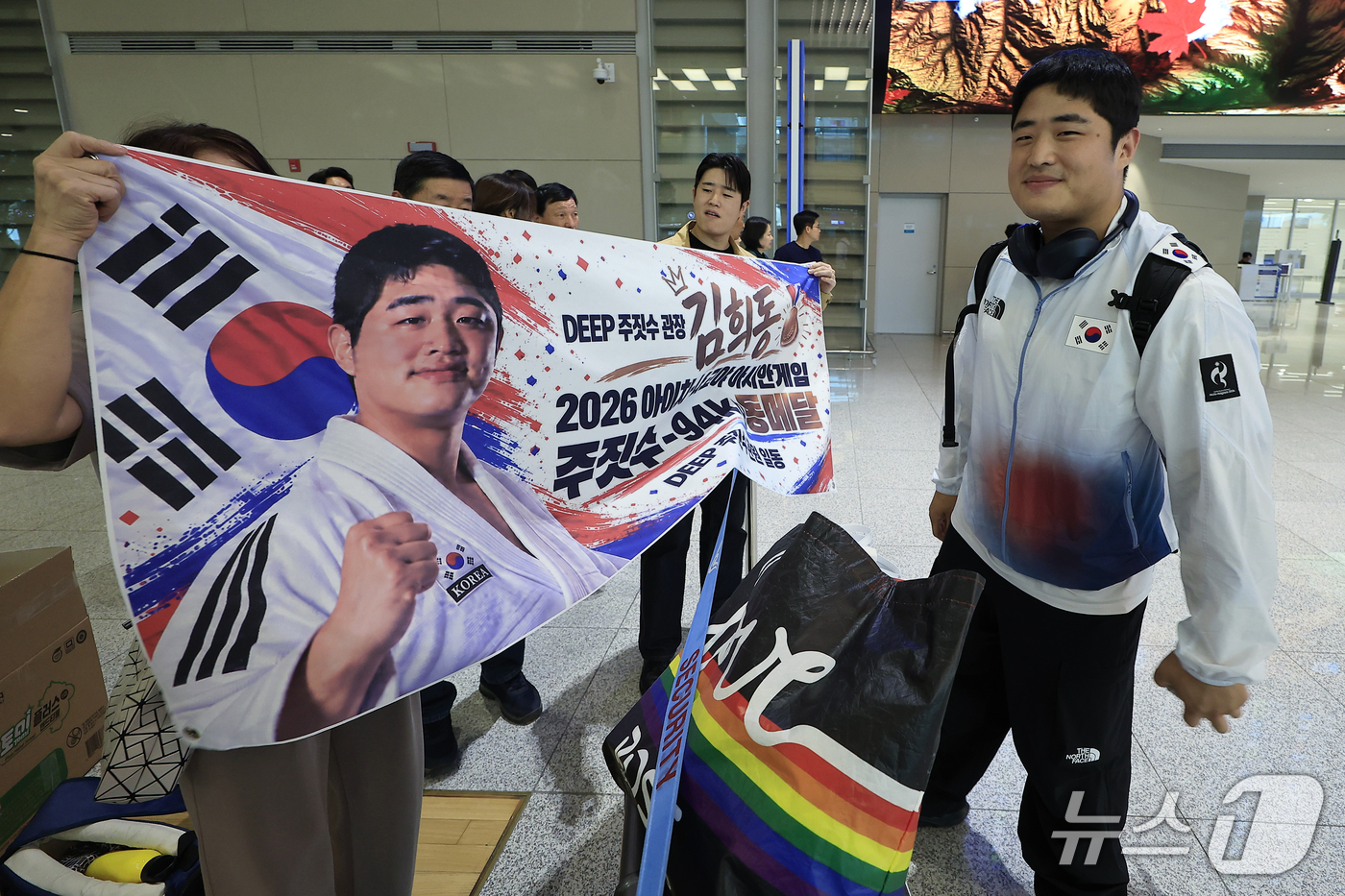 (인천공항=뉴스1) 박정호 기자 = 2026 아이치-나고야 아시안게임 남자 -94kg급에서 동메달을 차지한 김희동이 4일 오후 인천국제공항을 통해 귀국해, 가족들이 준비한 플래카드 …
