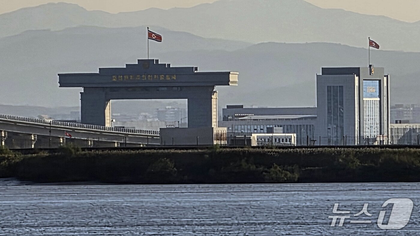본문 이미지 - 5일 중국 랴오닝성 단둥에서 바라본 신압록강대교 북한 측 세관 일대에 인공기가 휘날리고 있다. 2026.10.5 ⓒ 뉴스1 노민호 특파원