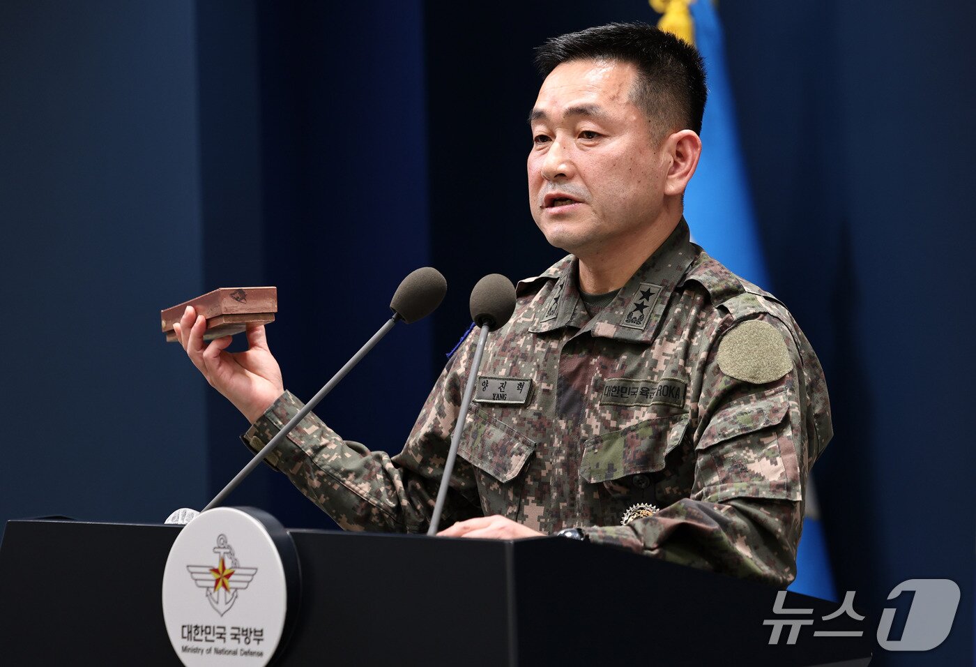 본문 이미지 - 양진혁 합동참모본부 작전부장이 5일 서울 용산구 국방부에서 북한군 수지반보병 지뢰를 들어보이며 육군 25사단 비무장지대(DMZ) 지뢰 폭발상황을 설명하고 있다. 2026.10.5 ⓒ 뉴스1 구윤성 기자
