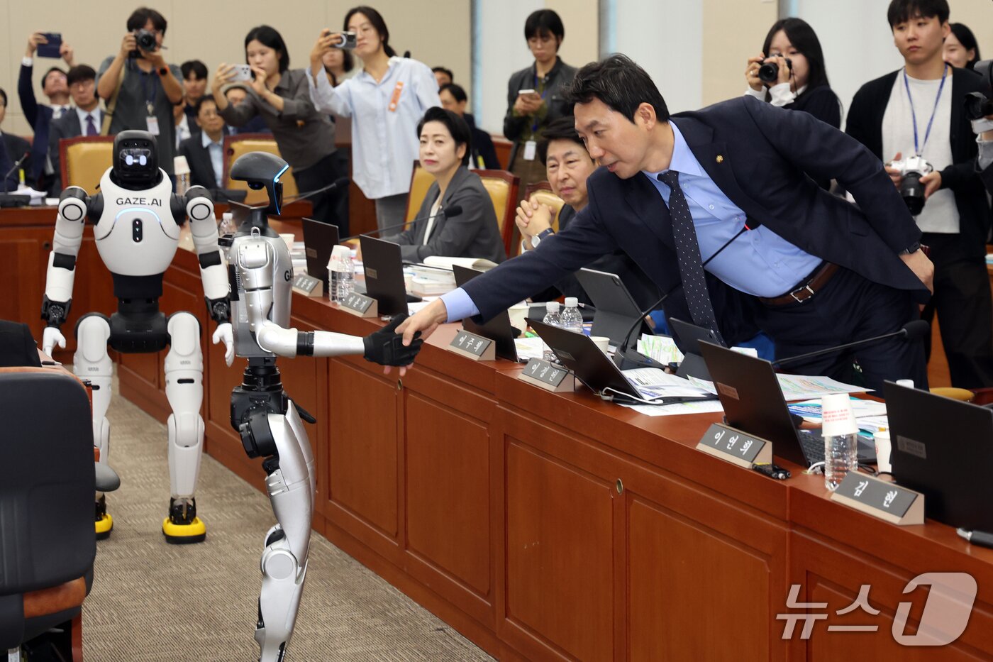 본문 이미지 - 이정헌 더불어민주당 의원이 6일 서울 여의도 국회 과학기술정보방송통신위원회에서 열린 과기부 등에 대한 국정감사에서 중국산 휴머노이드 로봇과 악수를 나누고 있다 2026.10.6 ⓒ 뉴스1 황기선 기자