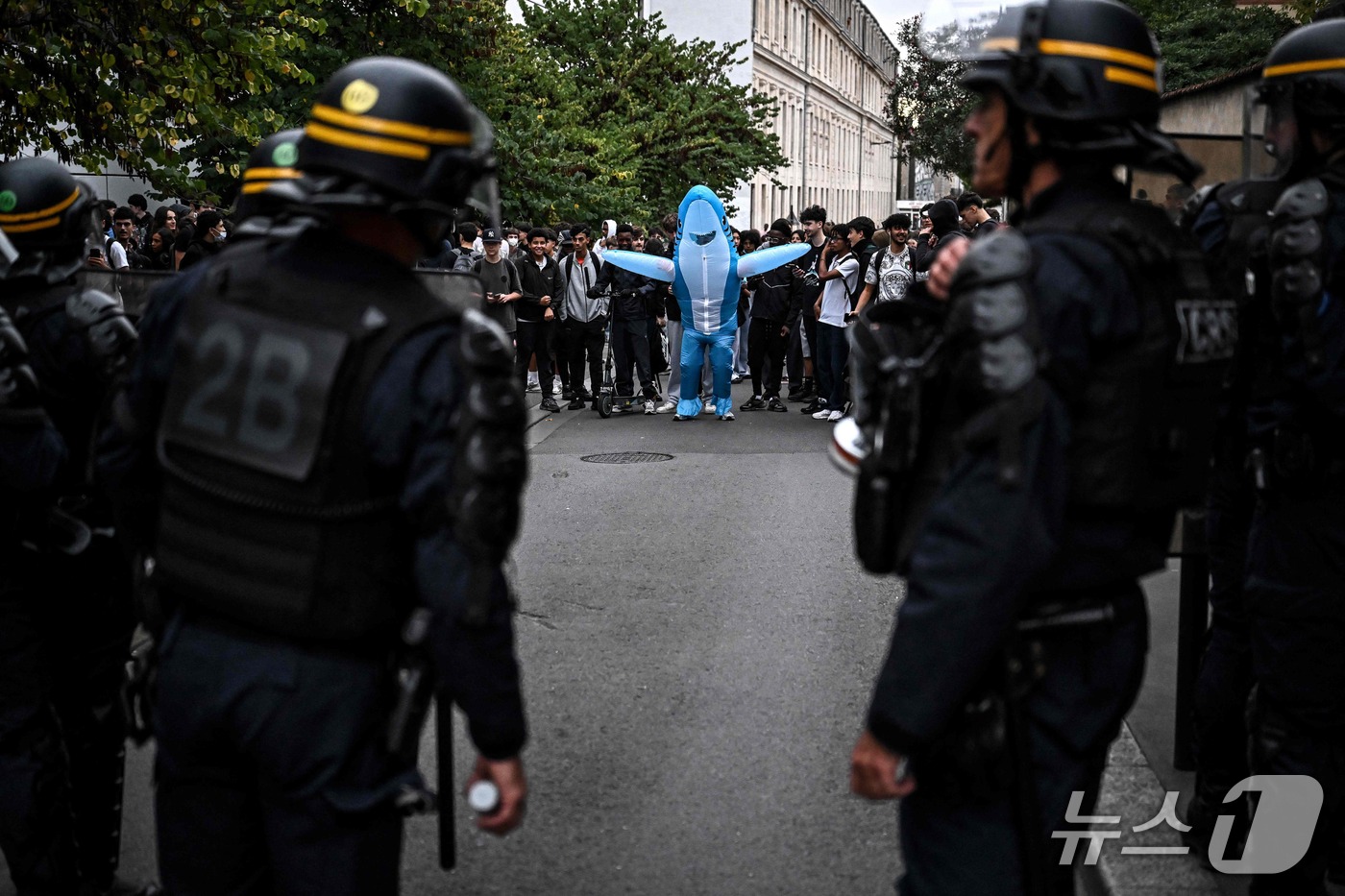 (보르도 AFP=뉴스1) 김범수 기자 = 5일(현지시간) 프랑스 남서부 보르도의 한 고등학교 밖 시위 현장에서 상어 복장을 한 시위 참가자가 진압 경찰 앞에서 지느러미를 벌리고 있 …