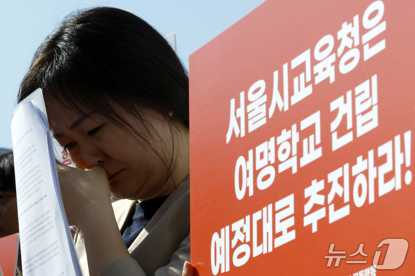 (서울=뉴스1) 박정호 기자 = 엄에스더 여명학교 졸업생이 7일 오전 서울시 중구 서울시의회 앞에서 열린 여명학교 교사 건립 촉구 기자회견에서 조명숙 교장 발언에 흐르는 눈물을 훔 …