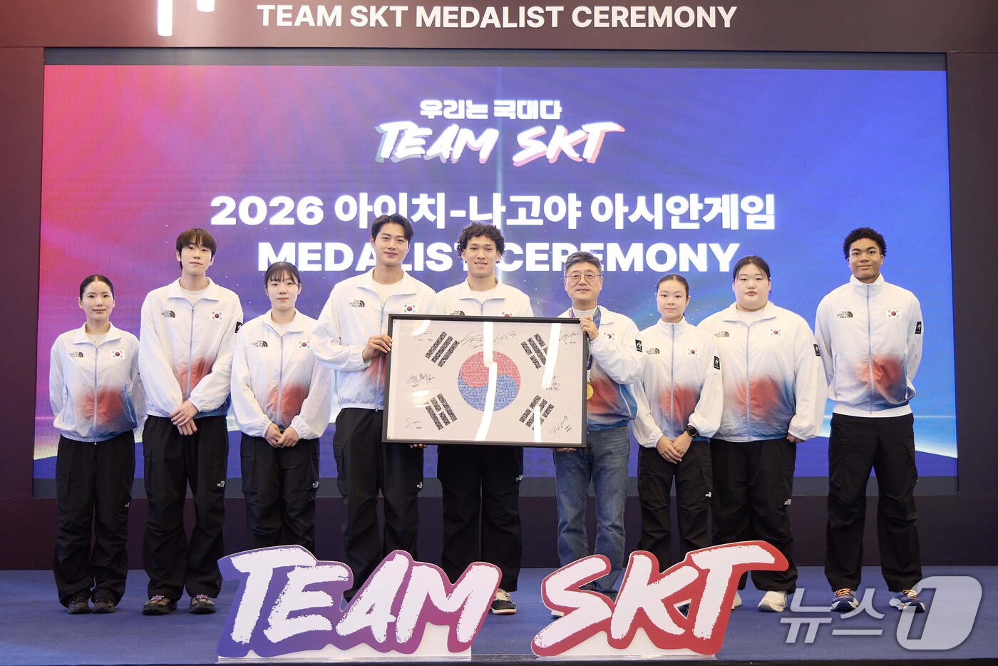 (서울=뉴스1) = 정재헌 SK텔레콤 CEO가 7일 서울 SKT타워에서 열린 2026 아이치·나고야 아시안게임 메달리스트 세리머니에서 '팀 SKT' 선수들의 사인을 담은 '국민응원 …
