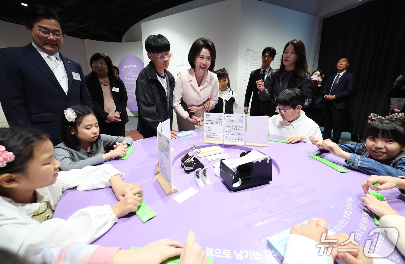 본문 이미지 - 김혜경 여사가 7일 인천 연수구 국립세계문자박물관에서 열린 훈맹정음 100주년 특별전 개막식에서 참석자들과 점자 체험을 하고 있다. 2026.10.7 ⓒ 뉴스1 이재명 기자