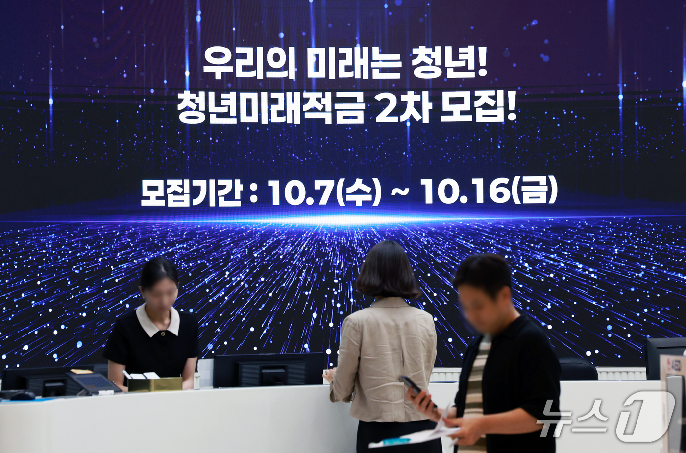 (서울=뉴스1) 이호윤 기자 = 청년미래적금 2차 가입 신청이 시작된 7일 서울 중구 우리은행 본점 스크린에 관련 안내문이 나오고 있다.금융위원회는 청년미래적금 2차 가입신청 기간 …