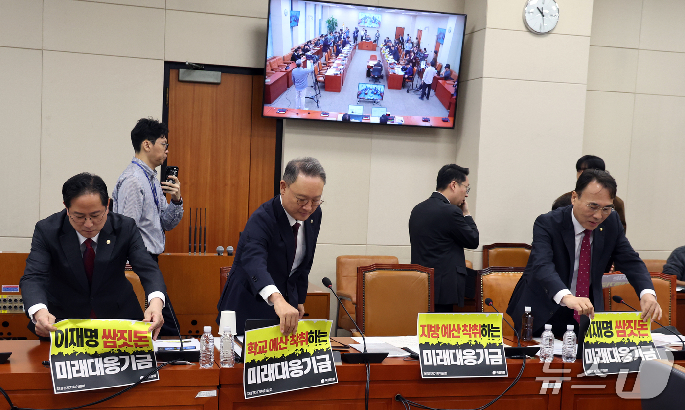 (서울=뉴스1) 황기선 기자 = 국민의힘 재경위 소속 의원들이 8일 서울 여의도 국회 재정경제기획위원회에서 열린 기획예산처에 대한 국정감사 개회를 앞두고 노트북에 붙인 피켓을 제거 …