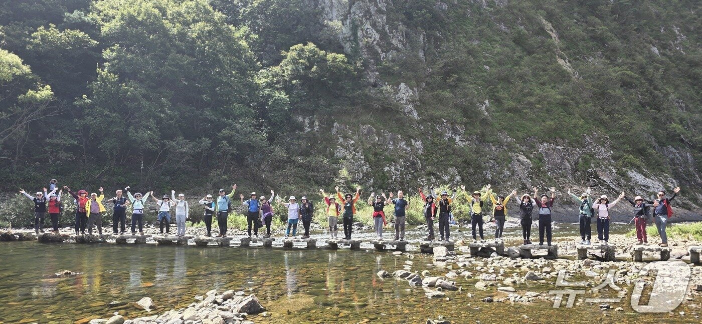본문 이미지 - 한국방송통신대학교 총동문산악회 회원들이 월류봉 광장 앞 징검다리를 건너고 있다.(영동군 제공. 재판매 및 DB 금지) 2026.10.8/뉴스1 