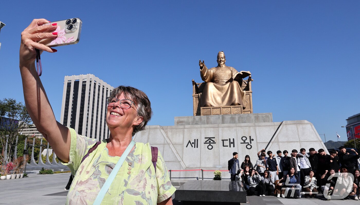 본문 이미지 - 한글날 제정 100주년을 하루 앞둔 8일 서울 종로구 광화문광장에서 외국인 관광객이 세종대왕 동상을 배경으로 셀피를 찍고 있다. 2026.10.8 ⓒ 뉴스1 박지혜 기자