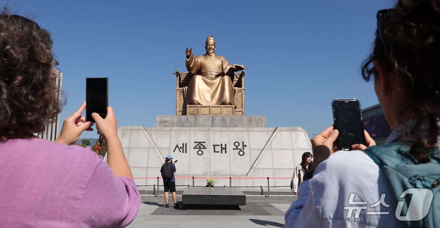 (서울=뉴스1) 박지혜 기자 = 한글날 제정 100주년을 하루 앞둔 8일 서울 종로구 광화문광장에서 외국인 관광객들이 세종대왕 동상을 스마트폰에 담고 있다.올해는 훈민정음 반포 5 …