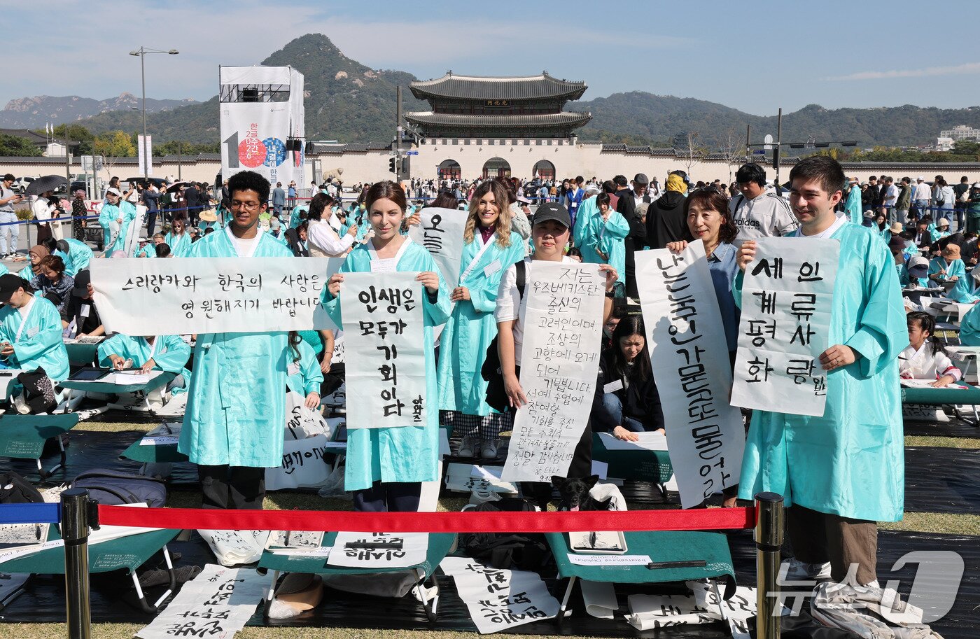 본문 이미지 - 한글날인 9일 오전 서울 광화문광장에서 한국예술문화원 주최로 열린 '광화문광장 휘호대회'에서 외국인 참가자들이 직접 쓴 한글 휘호를 들어 보이고 있다. 2026.10.9 ⓒ 뉴스1 박세연 기자