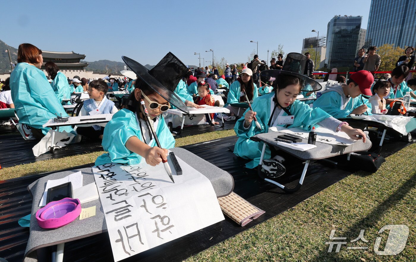 본문 이미지 - 한글날인 9일 오전 서울 광화문광장에서 한국예술문화원 주최로 열린 '광화문광장 휘호대회'에서 어린이 참가자들이 한글 휘호를 쓰고 있다. 2026.10.9 ⓒ 뉴스1 박세연 기자