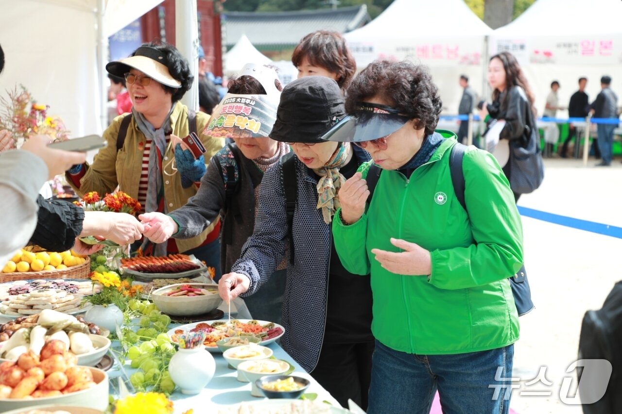 본문 이미지 - 9일 가을 국화 향연이 열린 충북 보은의 속리산 법주사를 찾은 시민들이 사찰 음식을 시식하고 있다.(보은군 제공.재판매 및 DB금지) 2026.10.9/뉴스1     